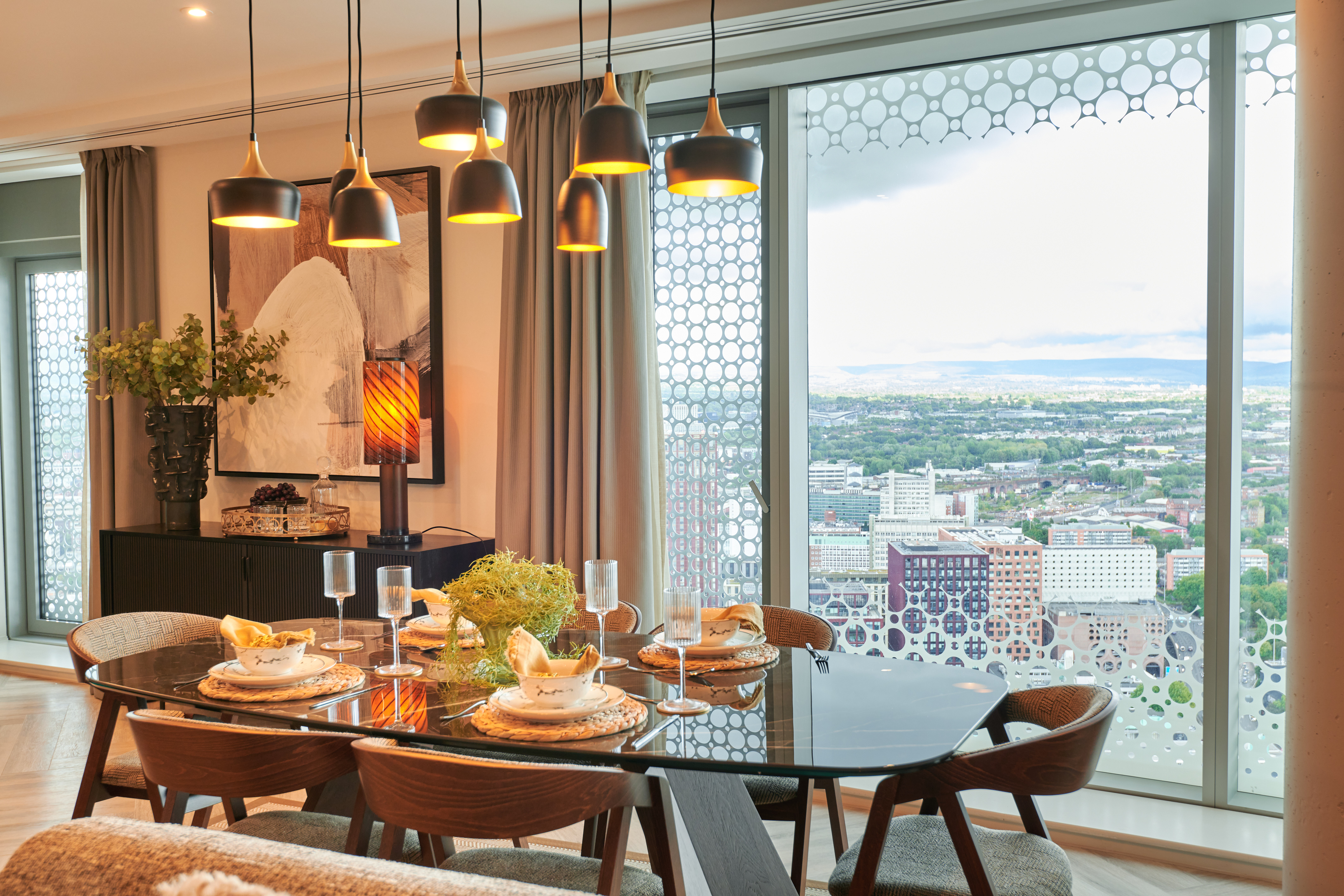 A dining table and a view over the city showing central Manchester living