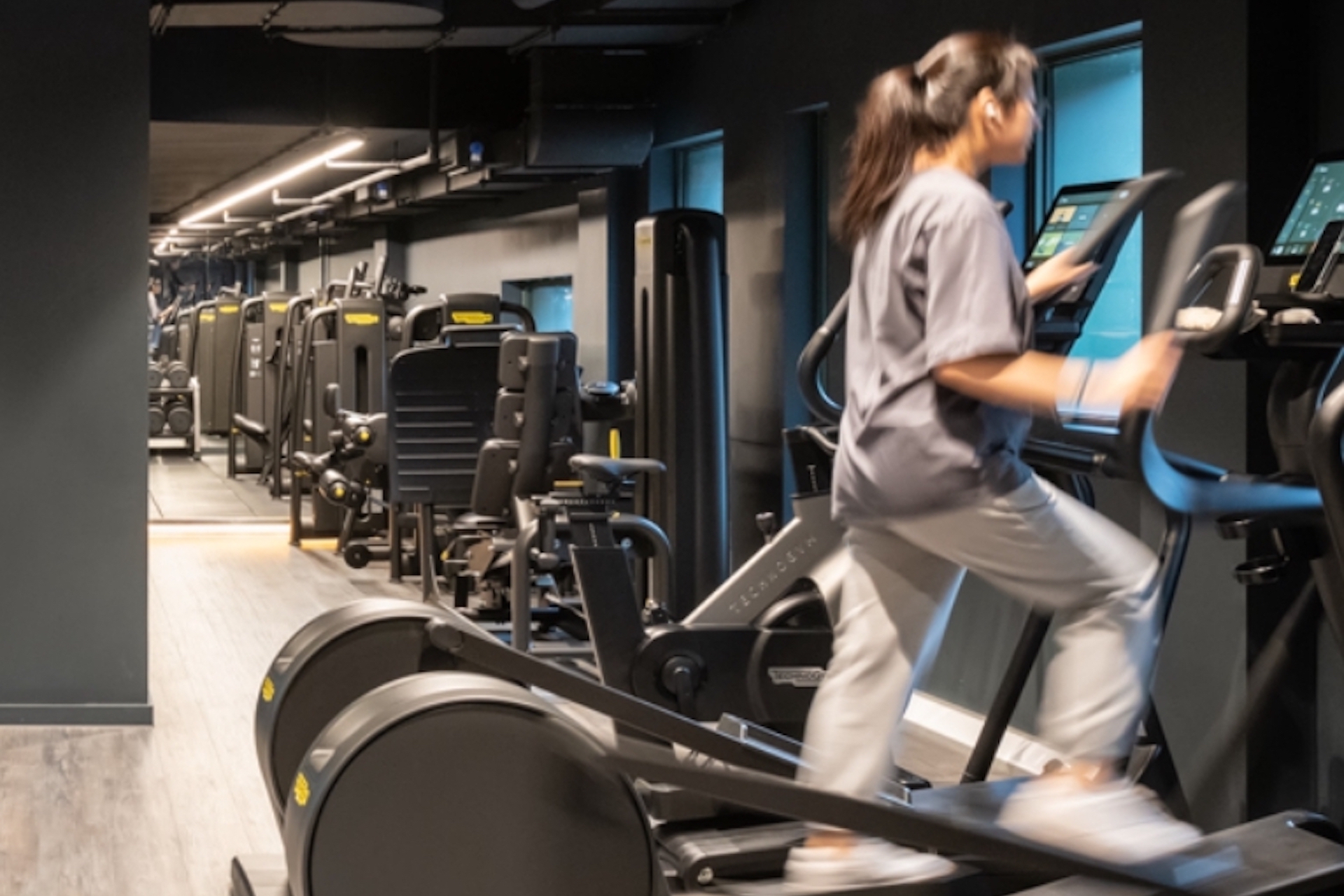 A woman working out in the Acer gym showing things to do on First Street
