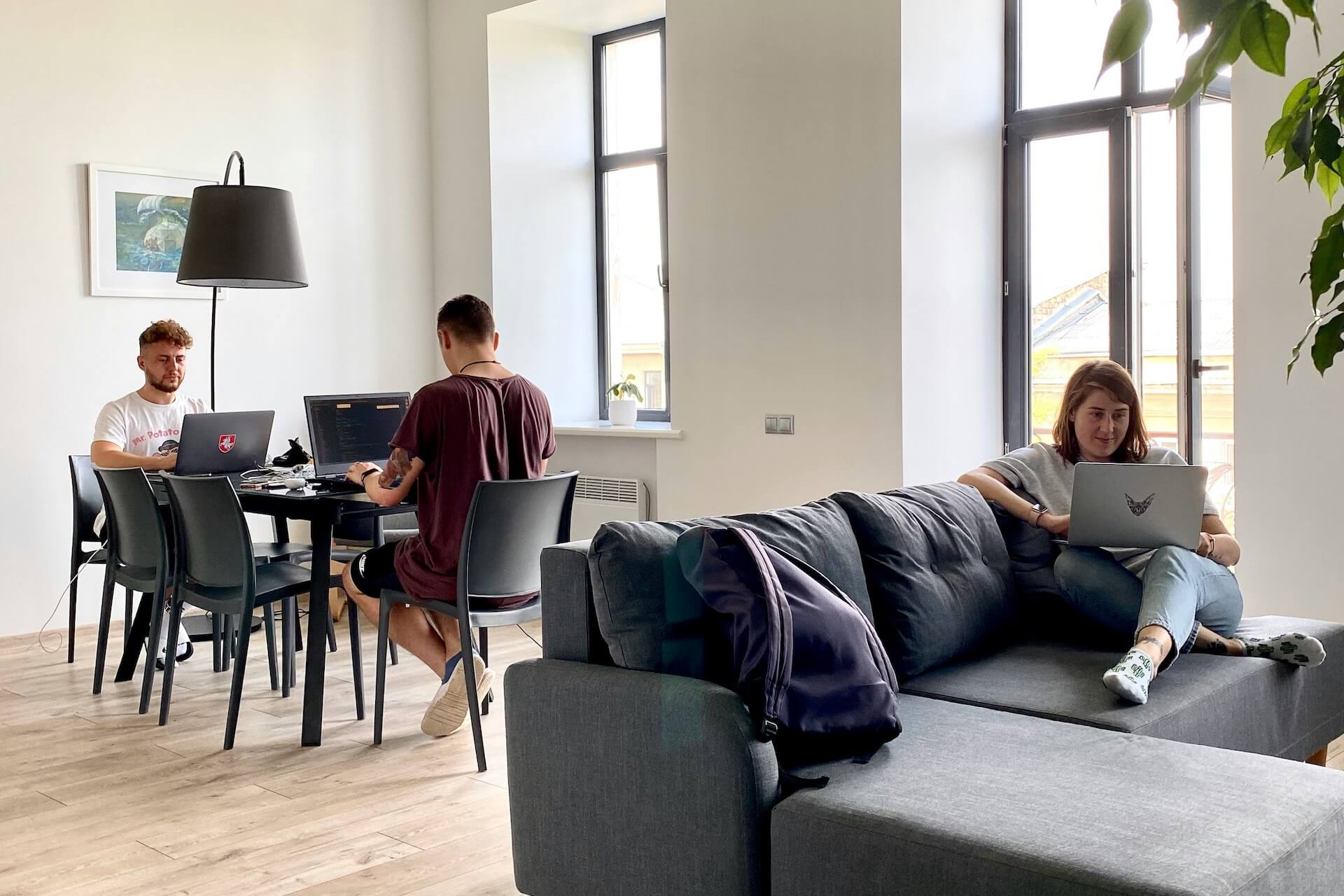 Young professionals working on their macbooks in a shared space showing the benefits of co-living in Manchester
