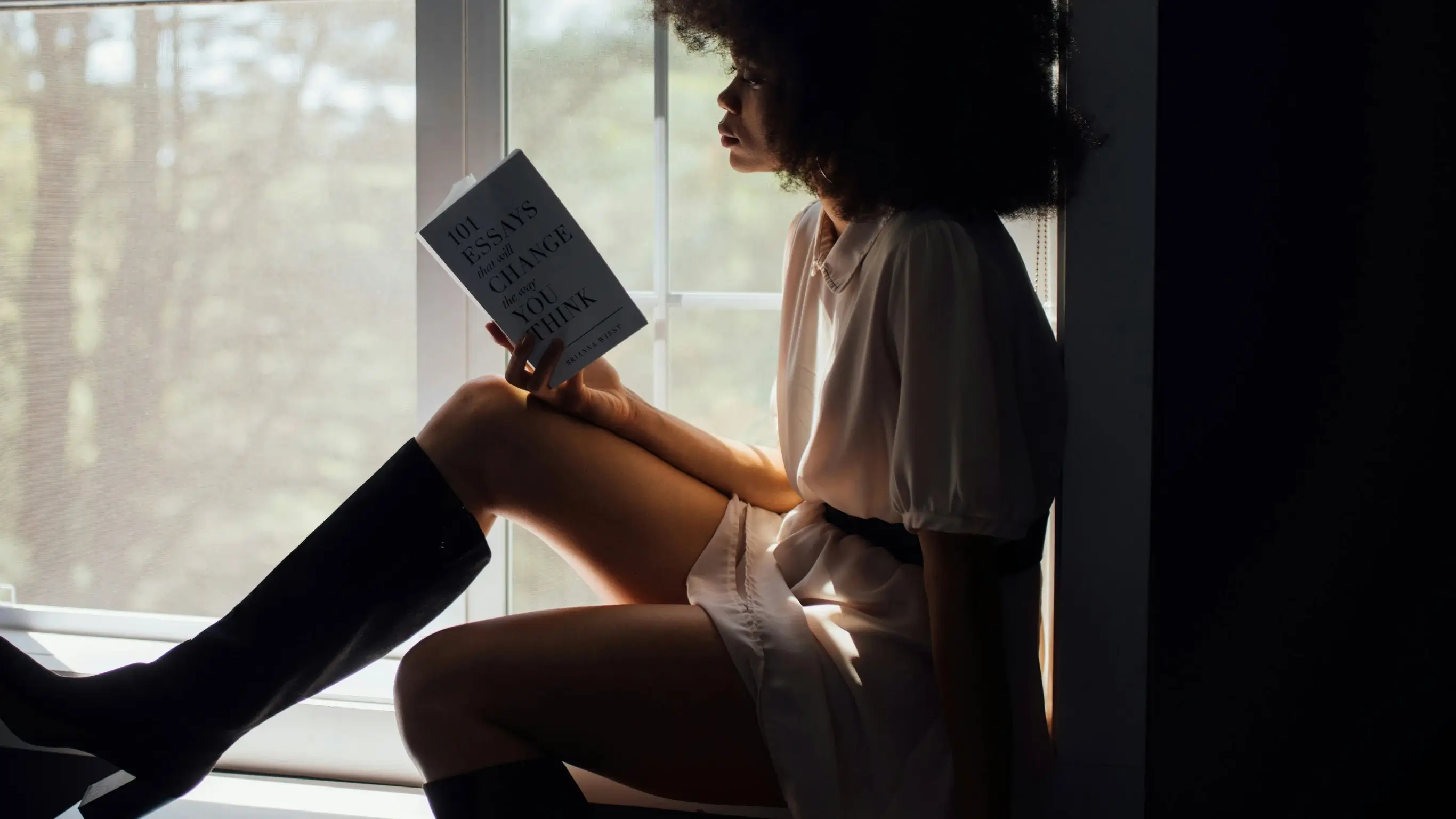 Student reading a book in her studio in Manchester